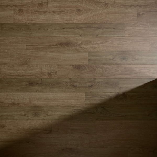 Newcastle Oak Brown* features light brown wooden floorboards with natural grain, knots, and subtle color variations. A diagonal shadow crosses the lower right corner of the floor.