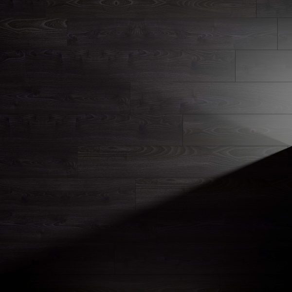 A Beaumont Oak floor with visible grain patterns is partially illuminated by a diagonal beam of light, creating a striking contrast between the lit and shadowed areas.