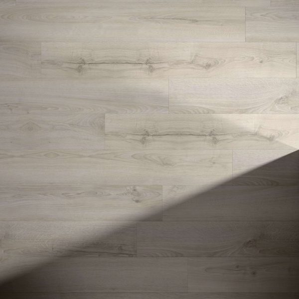 Inland* light wooden floorboards with visible grain and knots, partially covered by a diagonal shadow from the bottom right to center, create a striking contrast between illuminated and shaded areas.
